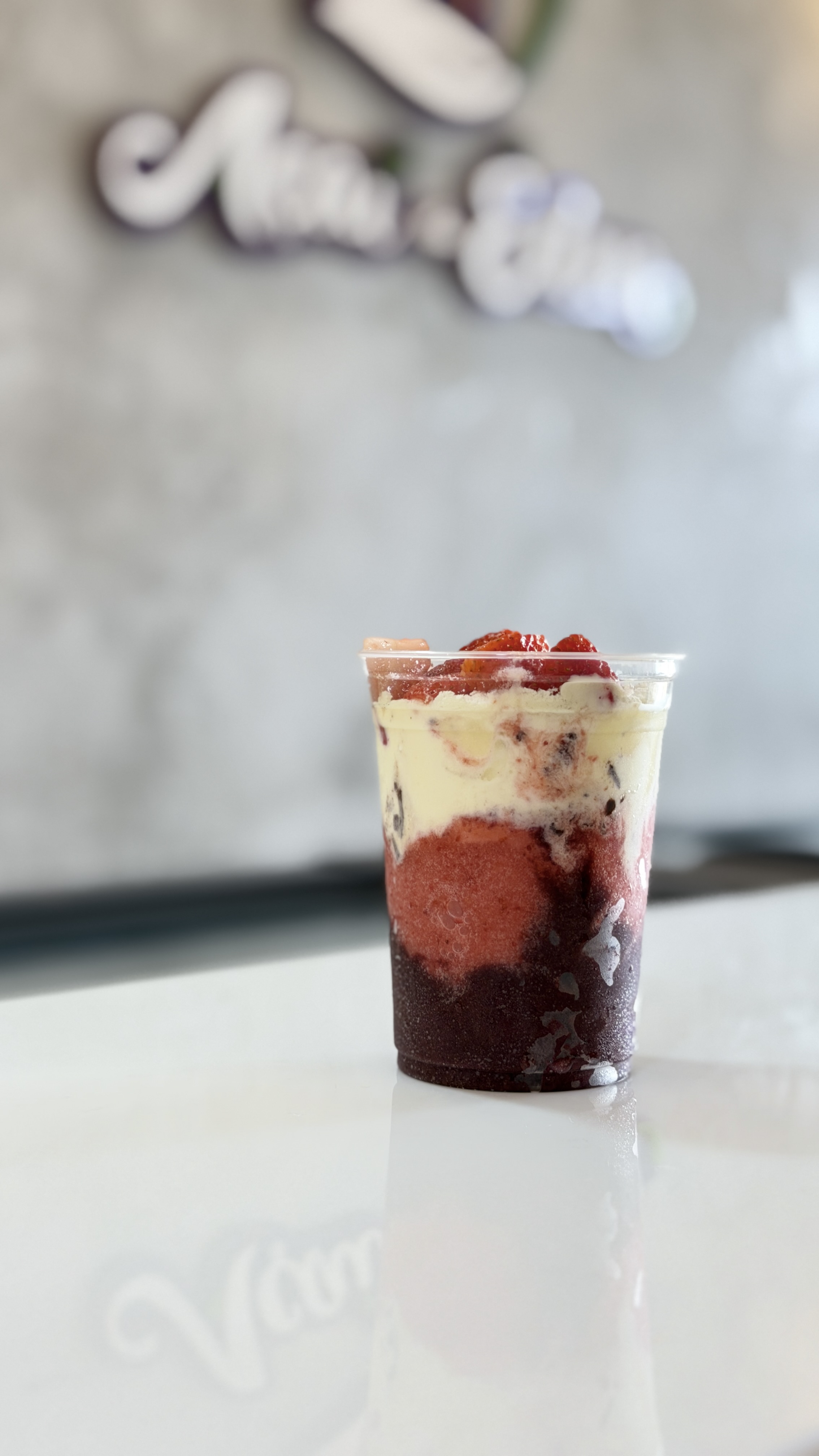 Copo de açaí em camadas com gelato e calda de morango